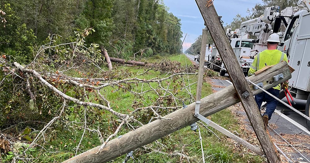 linemen repair damage caused by downed powerline due to hurricane Helene